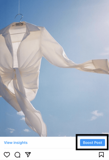 Instagram 發布了一件白色襯衫，襯著藍天，突出了提升發布按鈕。