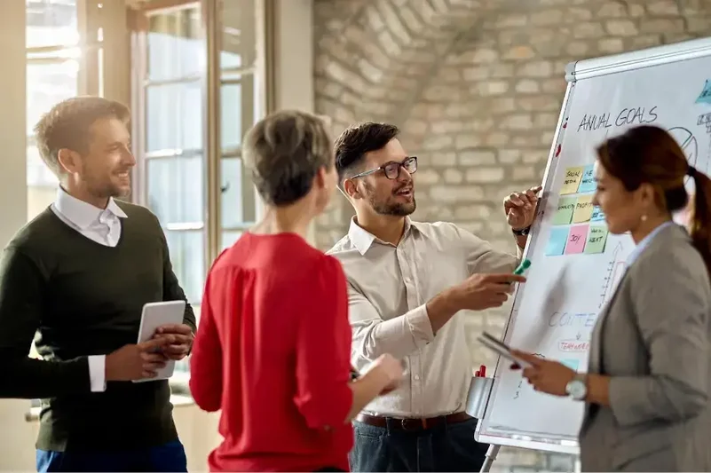 empleados poniendo-notas-adhesivas-en-la-pizarra