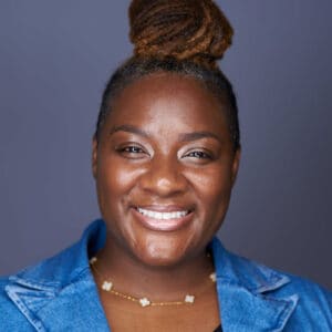 Foto de cabeza de Kartisha Henry con una camisa azul, sonriendo a la cámara