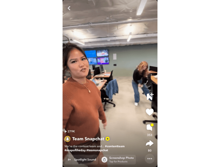 Snapchatの従業員がオフィス内を歩き回り、別の従業員がバックグラウンドで踊っているビデオのスクリーンショット。