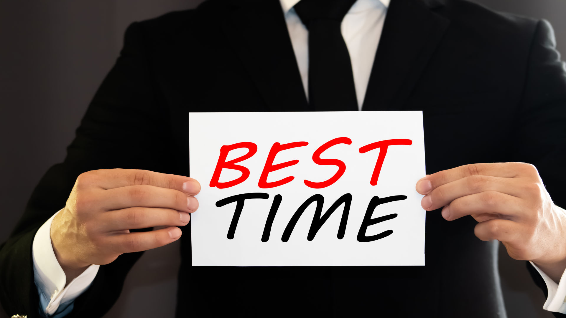 Un'immagine mostra un uomo in giacca e cravatta che tiene in mano la carta con il miglior tempo.