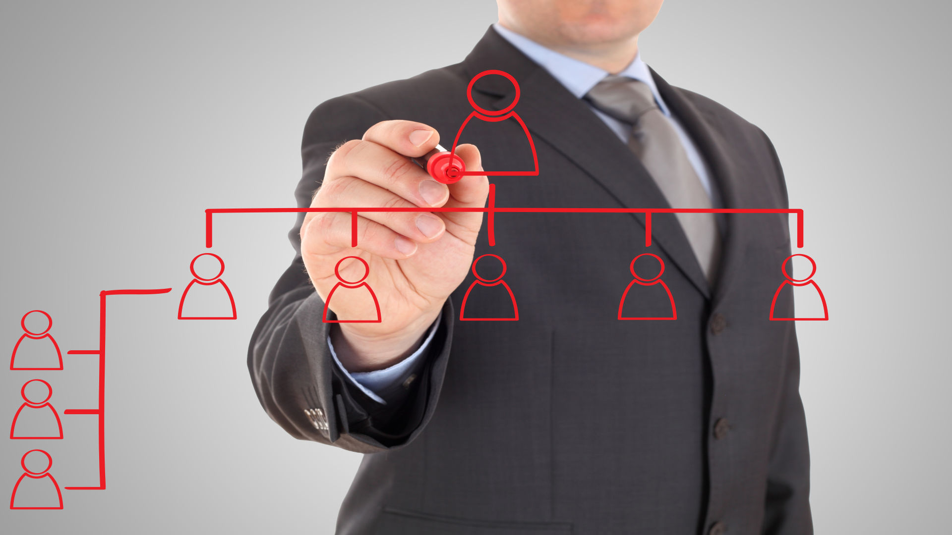 Un uomo in giacca e cravatta sta disegnando un organigramma.