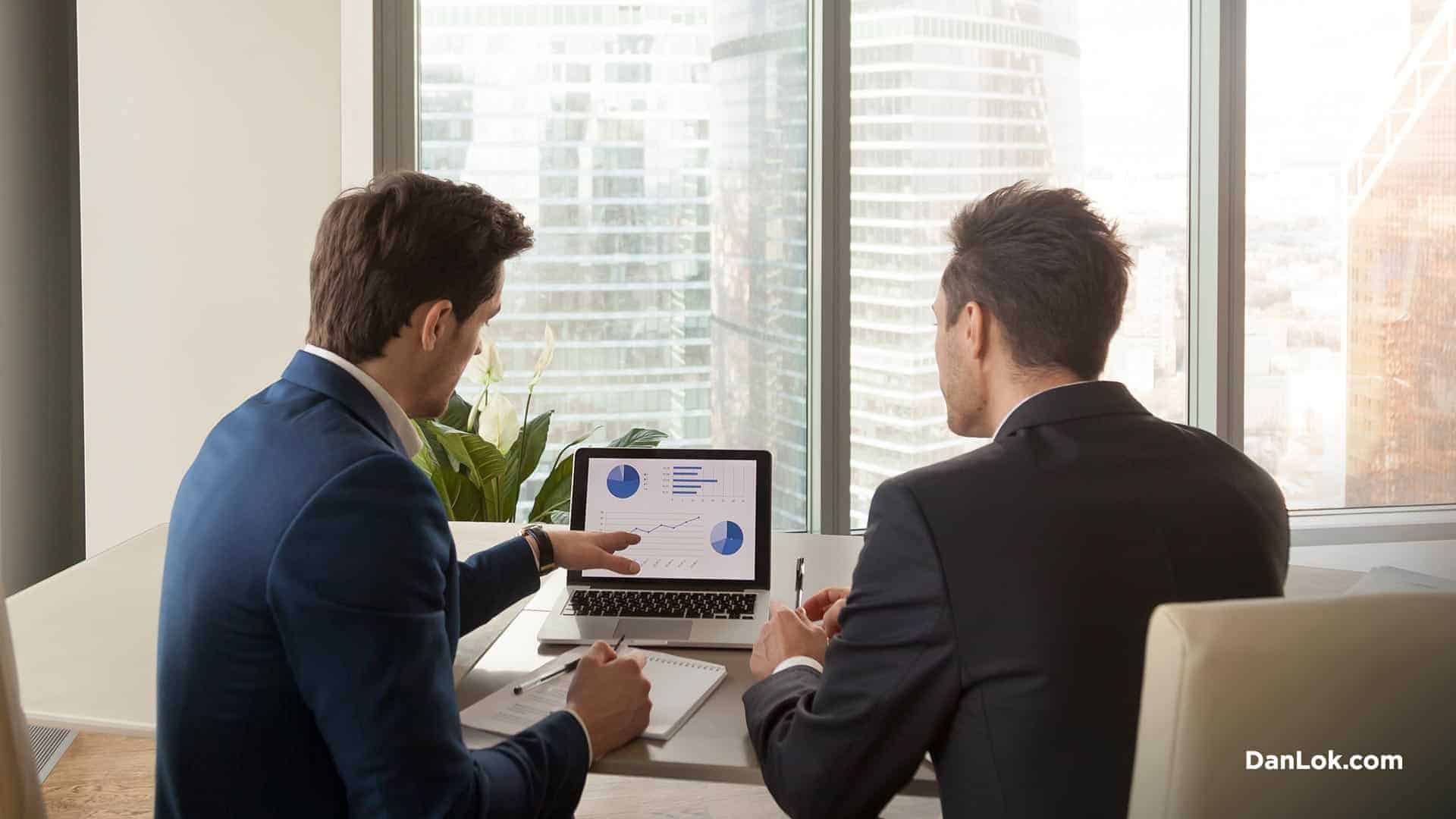 Двое мужчин смотрят на графики и обсуждают развитие своего бизнеса