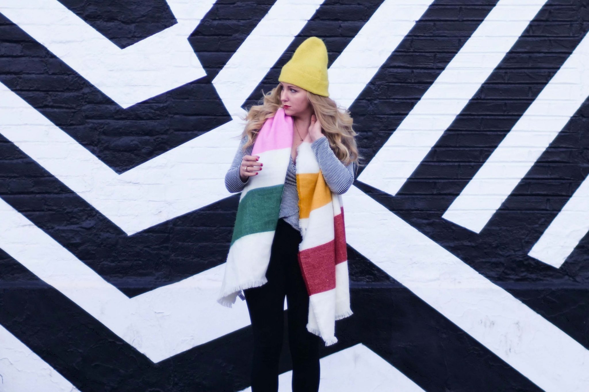 влиятельная женщина, стоящая перед черно-белой геометрической фреской